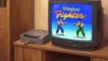 ブラウン管テレビにバーチャファイターのタイトル画面が映り、木製棚の上にセガサターン本体が接続されている構図