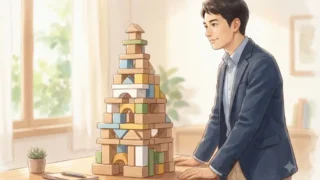 複数の積み木を組み合わせて作られた安定した塔とそれを見つめる日本人男性